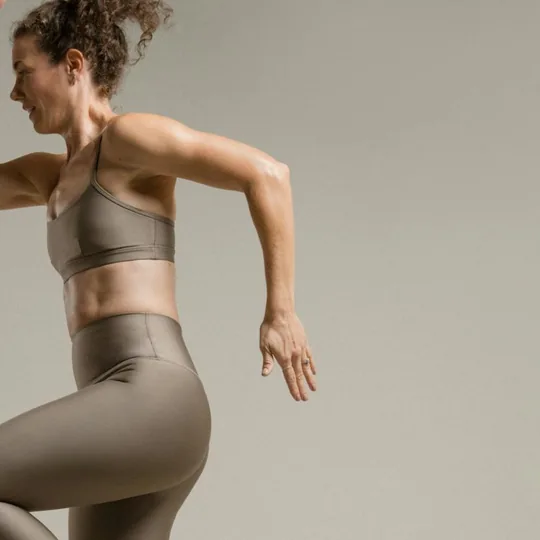 barre3 short-form post: a woman in mid-stride movement against a soft beige studio wall.