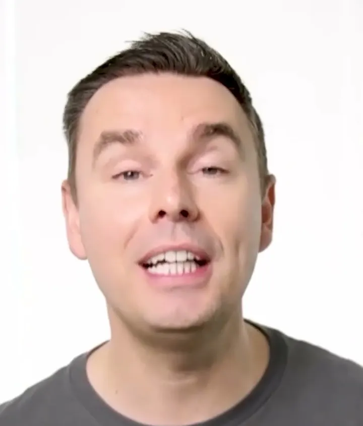 Brendon Burchard short-form post: a smiling man in a grey t-shirt talking to camera in front of a white background.