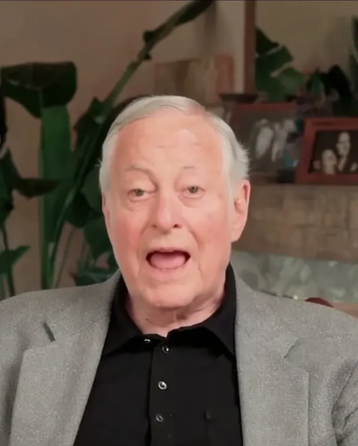 Brian Tracy short-form post: an older man with white hair in a grey blazer talking to camera in front of a plant and framed photos.