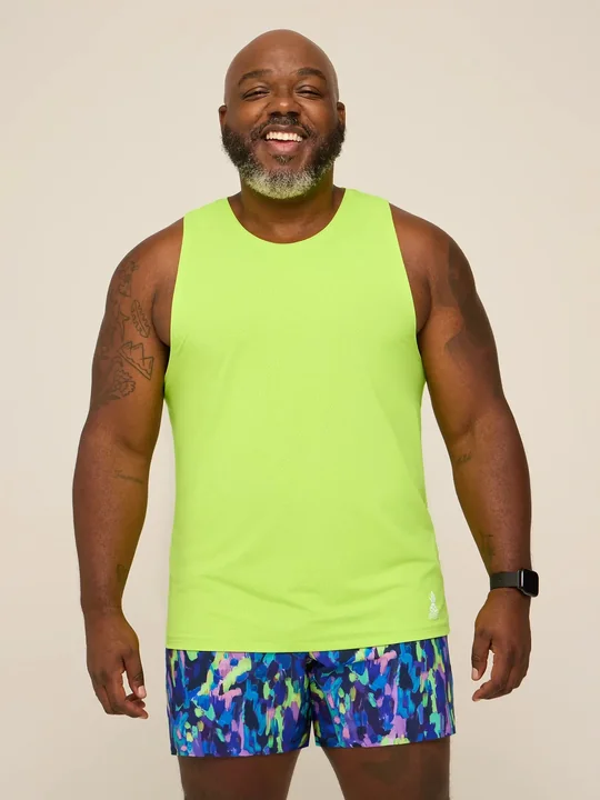 Chubbies short-form post: a smiling man in a neon yellow Zest rec tank and bright patterned shorts against a warm beige backdrop.