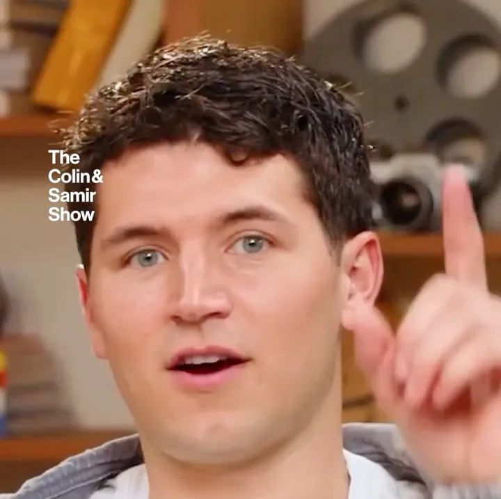 Colin and Samir short-form post: a young man in a white t-shirt raising a finger as he talks, with a title card reading “Nobody Starts Out Good at YouTube”.