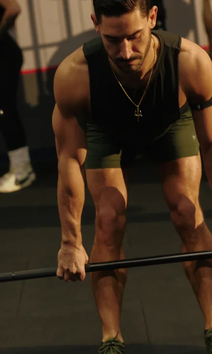 F45 Training short-form post: people in a gym lifting barbells off the floor in a group training class.
