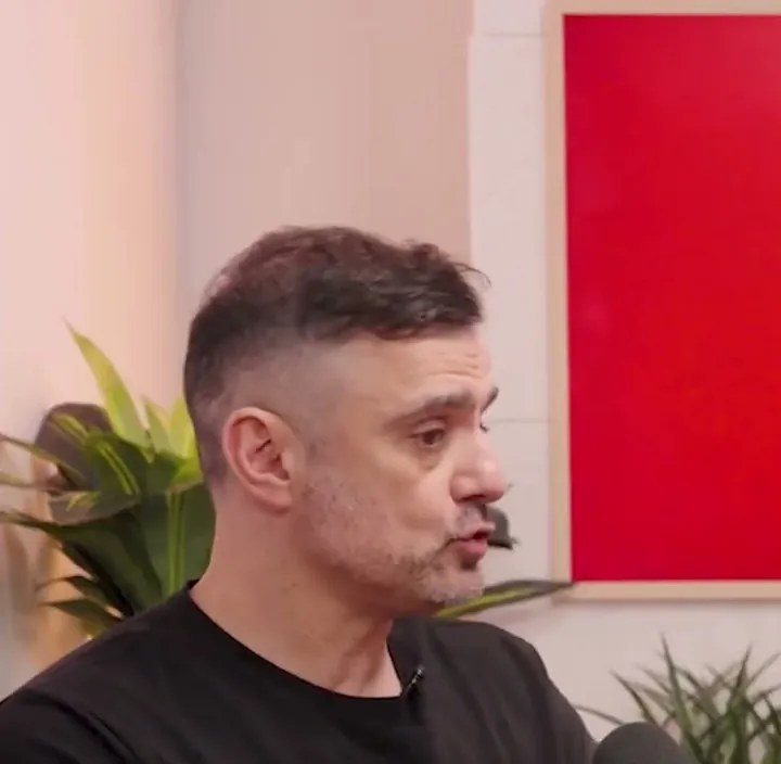 Gary Vaynerchuk short-form post: a man in a black t-shirt talking at a podcast set in front of a red panel.