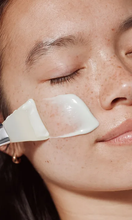 Heyday short-form post: a young woman with closed eyes as a glass facial tool glides across her cheek.