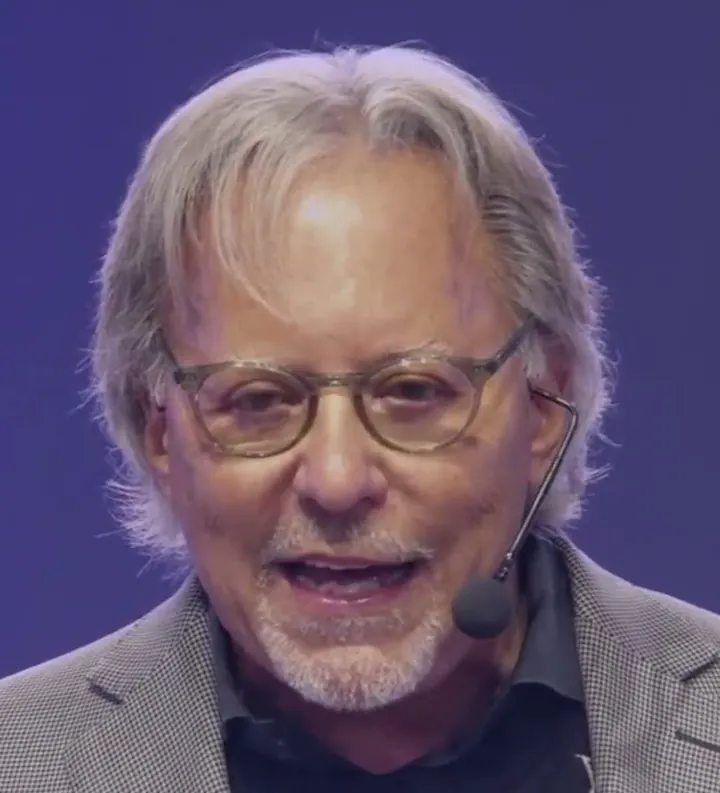 Jay Abraham short-form post: a man with grey hair and glasses wearing a headset microphone, speaking on stage against a purple backdrop.