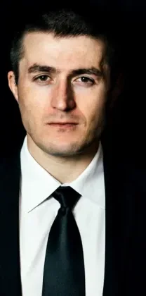 Lex Fridman Podcast short-form post: a man in a black suit and tie on a black background.
