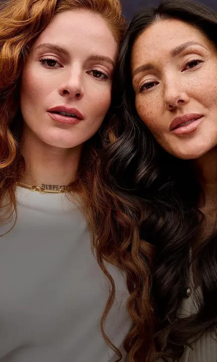 Madison Reed short-form post: two women with long red and dark waves leaning their heads together against a deep purple backdrop.