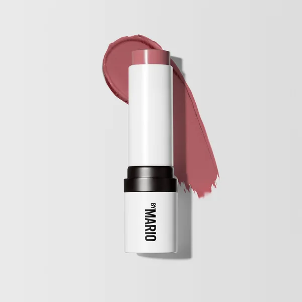 Makeup by Mario short-form post: a white Soft Pop Blush Stick standing upright with a swipe of dusty-rose blush behind it on a grey background.