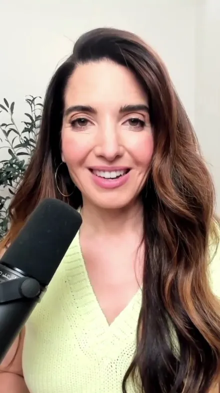 Marie Forleo short-form post: a woman with long dark hair speaking into a microphone in front of a bright window.