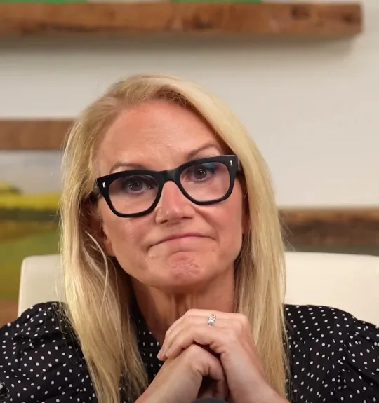 Mel Robbins short-form post: a woman with glasses and blonde hair speaking to the camera at a podcast desk.