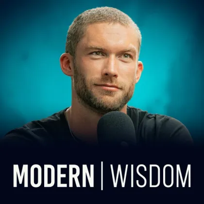 Modern Wisdom short-form post: the show's cover: a man with a short beard in a black top behind a microphone on a teal background.