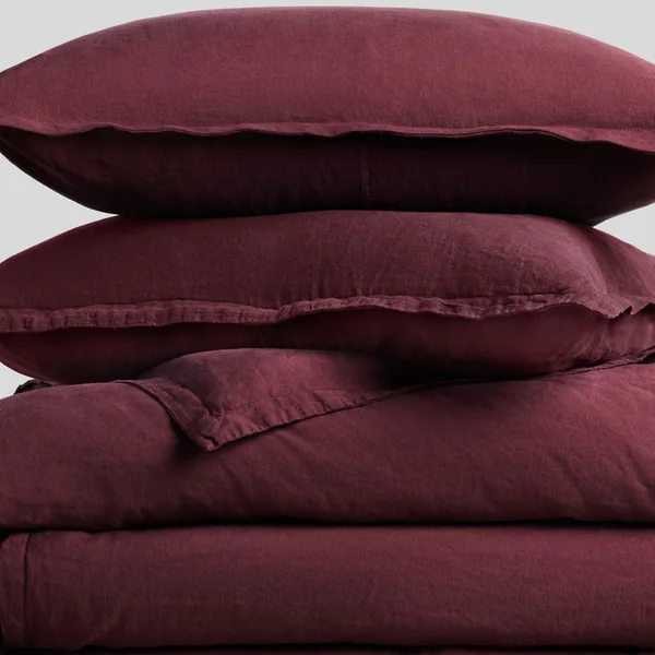 Parachute short-form post: stacked garnet linen pillowcases and a duvet cover with a soft crinkled texture.