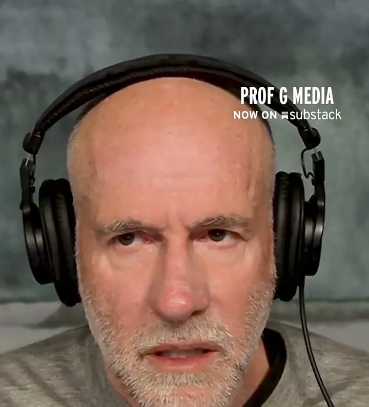 Scott Galloway short-form post: a bald man with a white beard wearing studio headphones, close to the camera.
