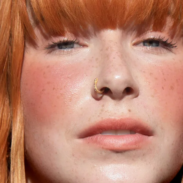 Tower 28 short-form post: a close-up of a freckled face with a soft cream blush on the cheeks.