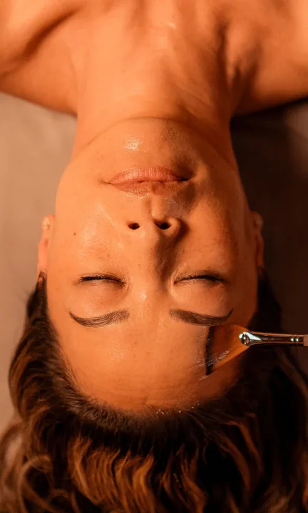 Woodhouse Spas short-form post: a woman lying back with closed eyes, photographed from above, as a tool rests near her forehead.